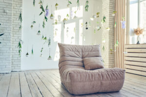 Interior design of room with soft sofa, artificial flowers levitating, hanging flowers on a white background.